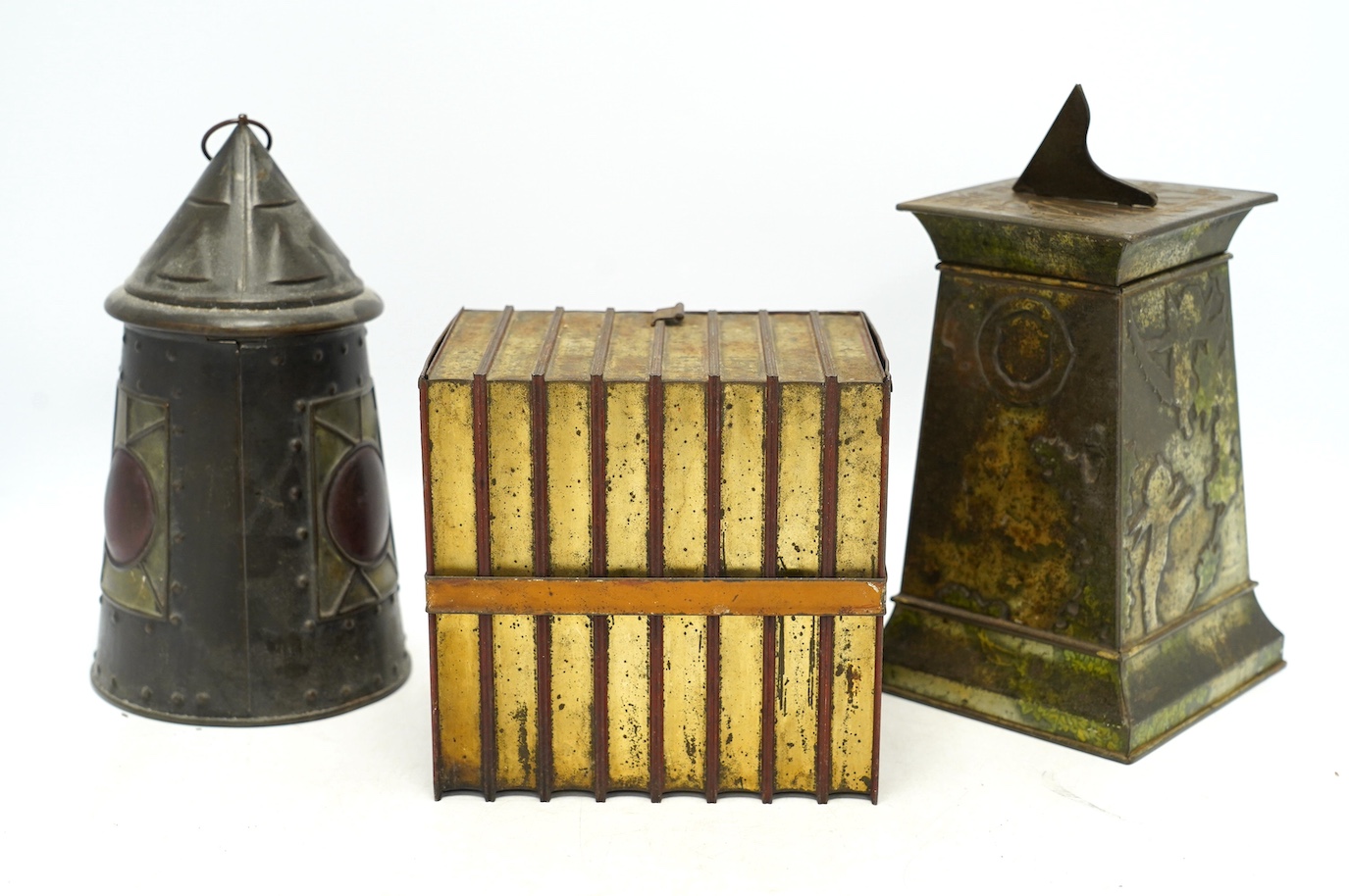 Three early 20th century Huntley & Palmer novelty biscuit tins, modelled as bound books, a sun dial and an Arts & Crafts lantern, largest 24cm high. Condition - fair